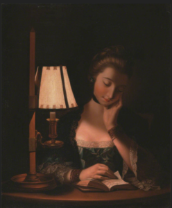 woman reading by a lamp
